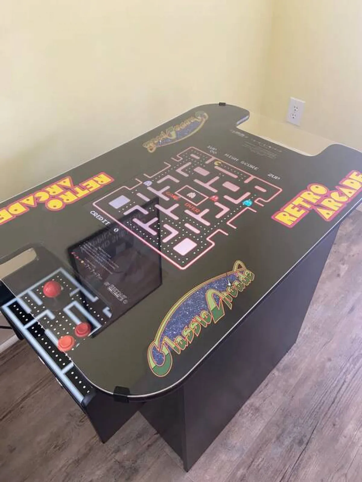 This image features a retro arcade game machine with brightly colored graphics and an inviting control panel, set within a lively and playful area designed for classic gaming. The arcade cabinet is the main focus, evoking nostalgia and fun moments of friendly competition.